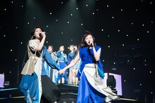 手をつないでステージを歩く小林歌穂（左）と中山莉子（右）。