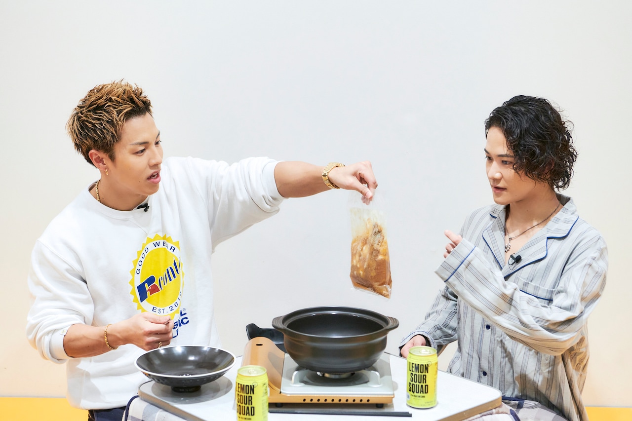 もつ入りスープを岩谷さんに手渡す鍋奉行RIKUさん。