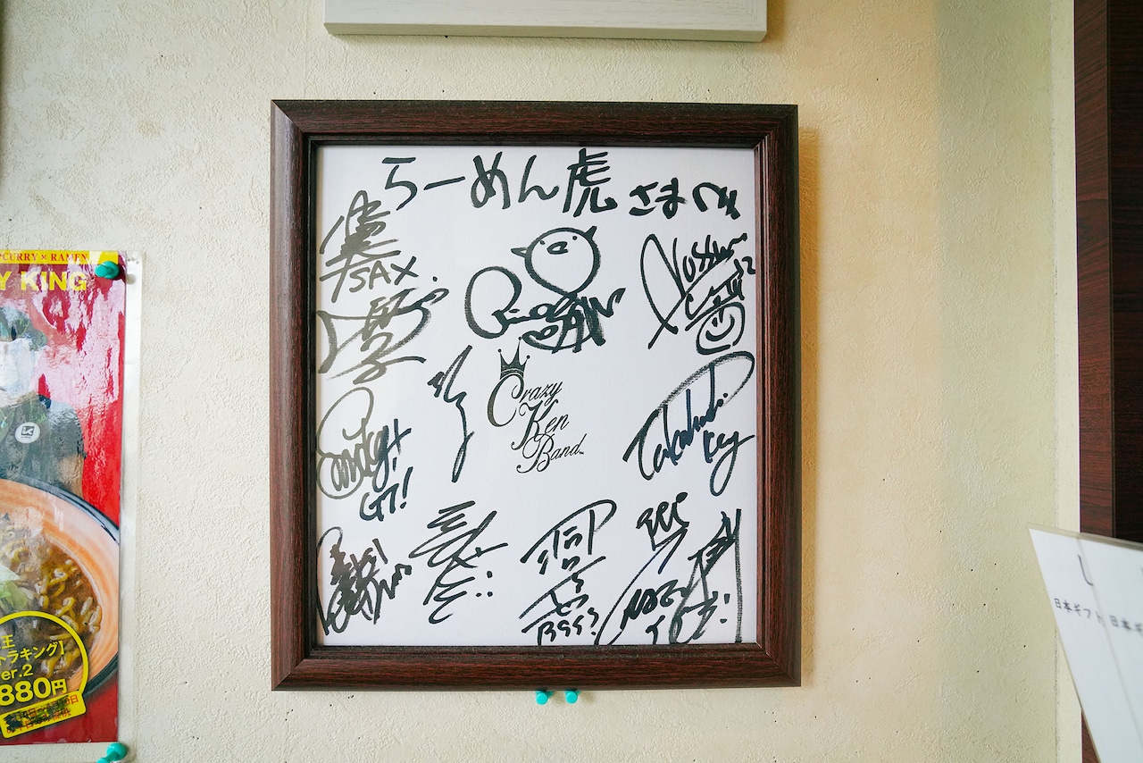 入り口に飾られたクレイジーケンバンドのサイン色紙。