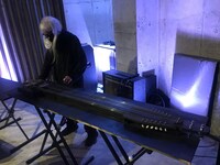 ヨシダが制作した「エレクトリック・ベース・タンブーラ」を弾く灰野敬二。