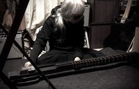 ヨシダが制作した「エレクトリック・ベース・タンブーラ」を弾く灰野敬二。