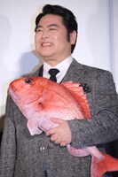 鯛を小脇に抱える皆川猿時。