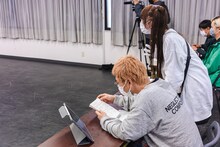 ユメカノートを見る渡辺淳之介（WACK代表）と、ユメカ・ナウカナ？（ASP）。