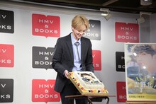 ケーキを報道陣に見せる吉野北人。