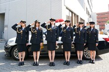 パトカーの前で敬礼する超ときめき♡宣伝部。