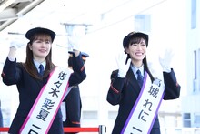 ももいろクローバーZのオリジナルヘッドマークを掲出した列車を見送る佐々木彩夏（左）と高城れに（右）。