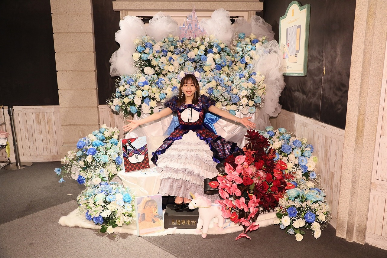 フラワースタンドと記念撮影する大場美奈。