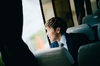 バスの座席から降車を見上げるRIKU。