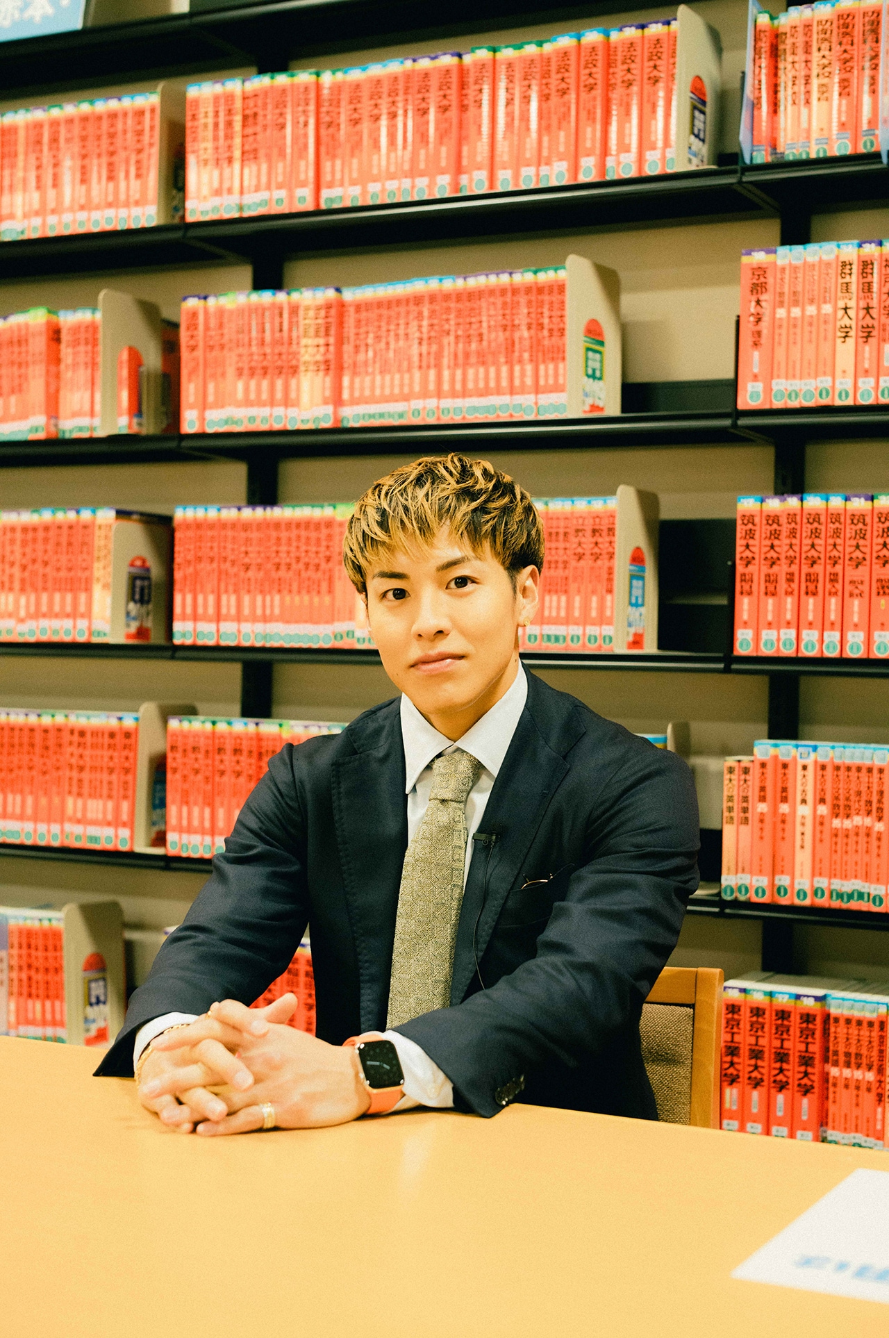 赤本がずらりと並ぶ本棚の前で。