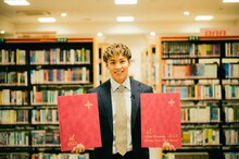 卒業アルバムを持ったRIKU。