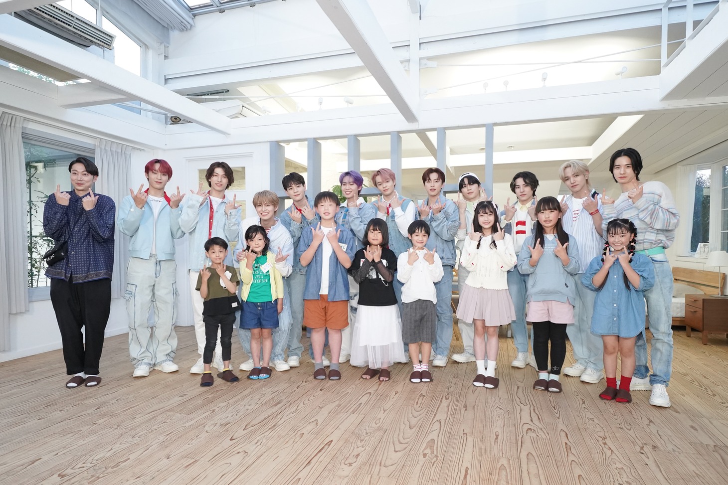 小学生取材会の集合写真。司会の金田哲（はんにゃ） 、JO1、小学生記者たち。