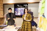 付箋が貼られたホワイトボードを見つめるのっちさん（右）。