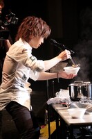 牛すじ煮込みを器に盛る鬼龍院翔。