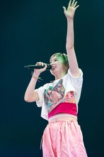 笑顔で大きく手を振る安本彩花。