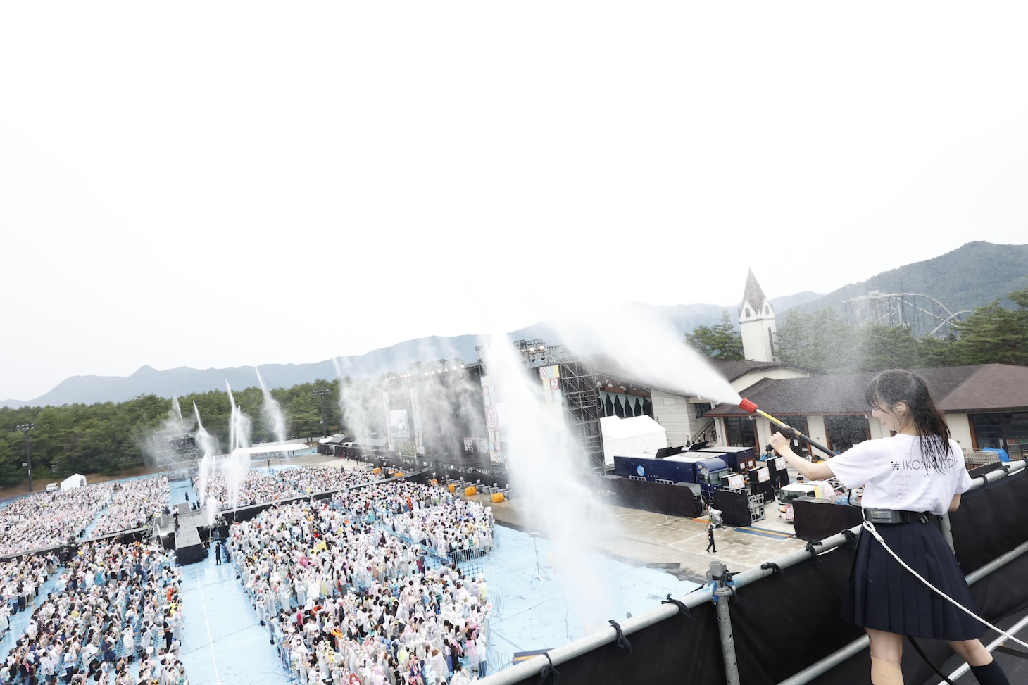 客席に向かって水を撒くメンバーたち。(c)YOANI