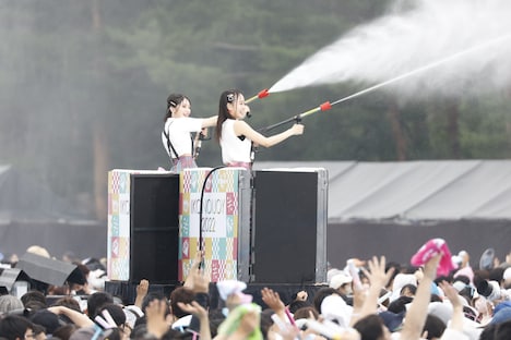 トロッコの上から放水銃で水を撒くメンバーたち。(c)YOANI