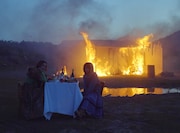 AAAMYYYとanoが食事、燃え盛る小屋の前で