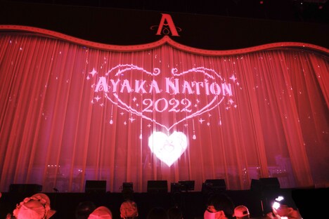 ステージ上の幕に映し出された「AYAKA NATION 2022」のロゴ。（撮影：上飯坂一）