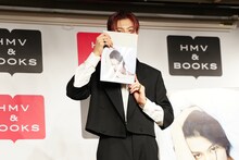 顔を隠す長谷川慎。