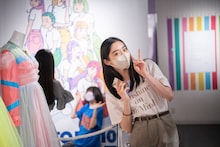 自分の衣装の前で記念撮影する風見和香。