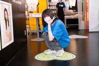 自分の担当カラーであるライトグリーンの校章と一緒に記念撮影する小久保柚乃。