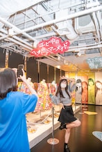 自身のキャッチフレーズの下で記念撮影する桜木心菜。