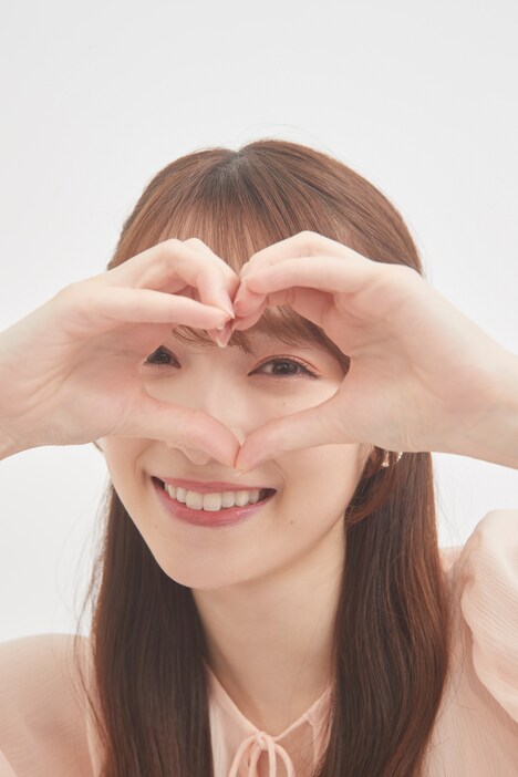 ハート越しにカメラを見つめる守屋麗奈。 (c)Seed & Flower LLC/竹書房 撮影:NAE.