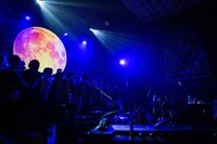 観客の背後に浮かぶ月。