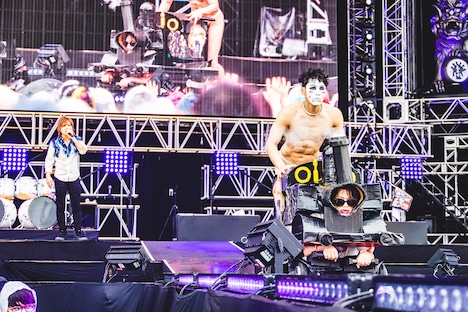 “HYDE列車”に乗って花道を疾走する樽美酒研二（Dr）と、それを見送る鬼龍院翔（Vo / ゴールデンボンバー）。（撮影：青木カズロー）