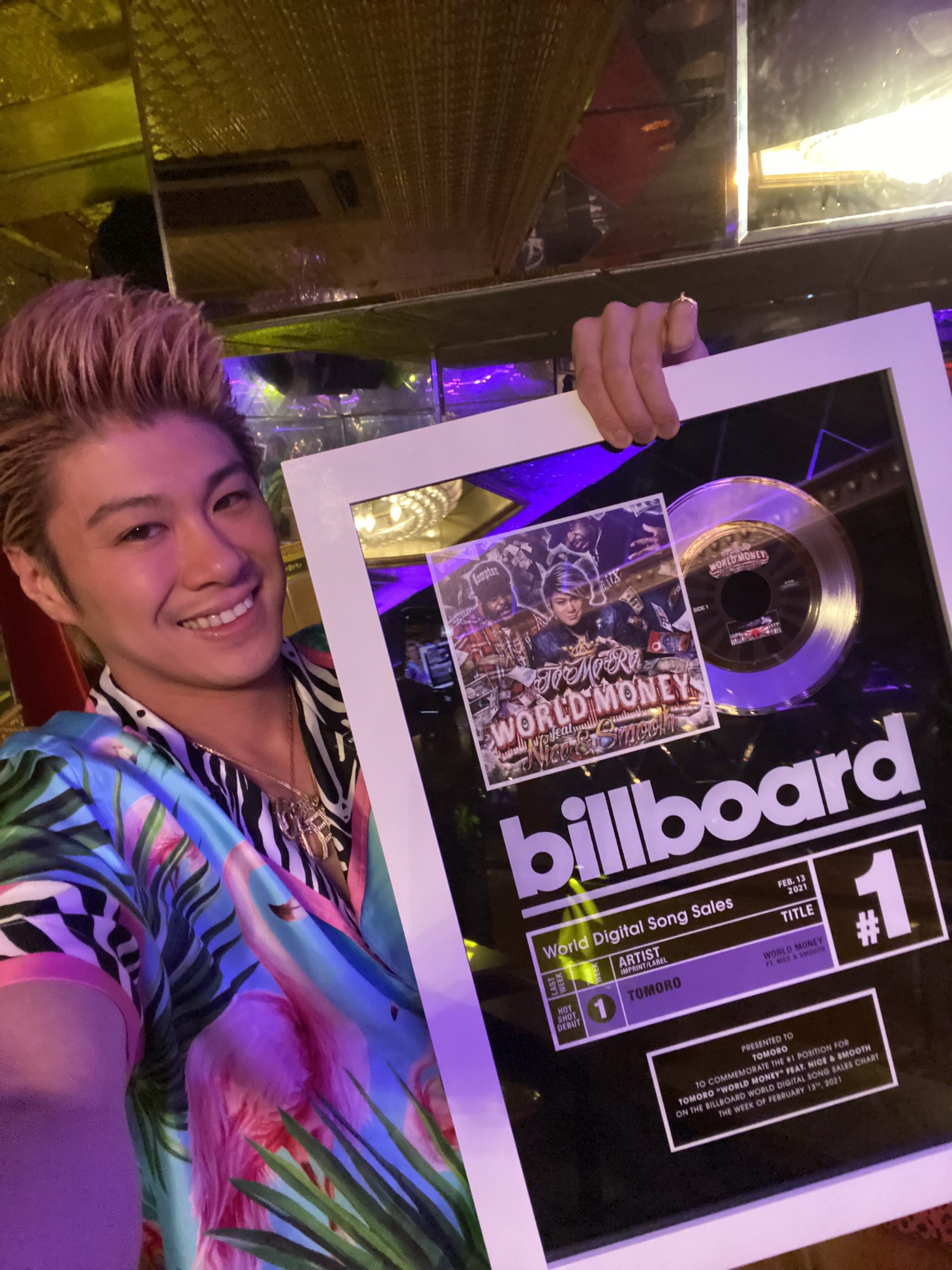 Billboardチャート1位の表彰状を持つTOMORO。