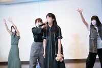 犬のぬいぐるみを手に歌う中山莉子（中央）。