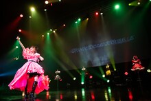 歴代衣装をバックに歌う星名美怜。