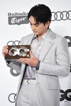 トロフィーを見つめる町田啓太。