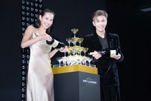 シャンパンをグラスのタワーに注ぎ入れる水原希子（左）、岩田剛典（右）。