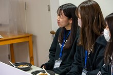 辛いものを食べる演技中のアイカ・ザ・スパイ。