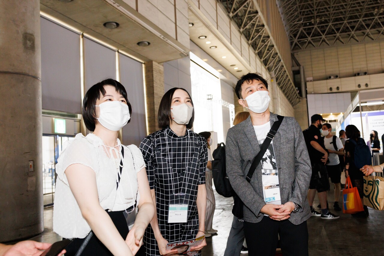 ブースを眺めながら歩く3人。