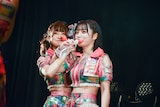 腕をクロスさせて水を飲む原田珠々華と石浜芽衣。