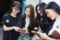 土岐さんのCDのジャケットを見ながら和気あいあいと話すMAMAMOOの4人。