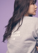 「NO COFFEE × FIRSTORDER CREW SWEAT SHIRTS（GRAY）」のバックプリントを見せる鈴木愛理。