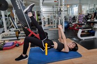 脚とお尻と上げた状態を保ちつつ、カメラに笑顔を見せる隈本茉莉奈さん。