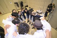 円陣を組むGran☆Cielとバンドメンバー。