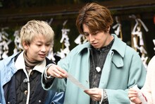 おみくじの運勢を見るタカシ（右）とシューヤ（左）。