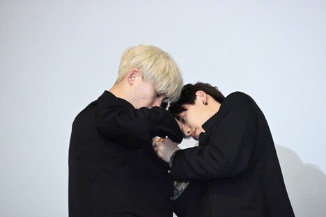 沢村玲（REI）の第二ボタンを外そうとする関哲汰（TETTA）。