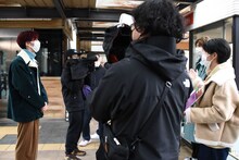 カイチームの街ぶらロケを見学するリョウガ（左）。