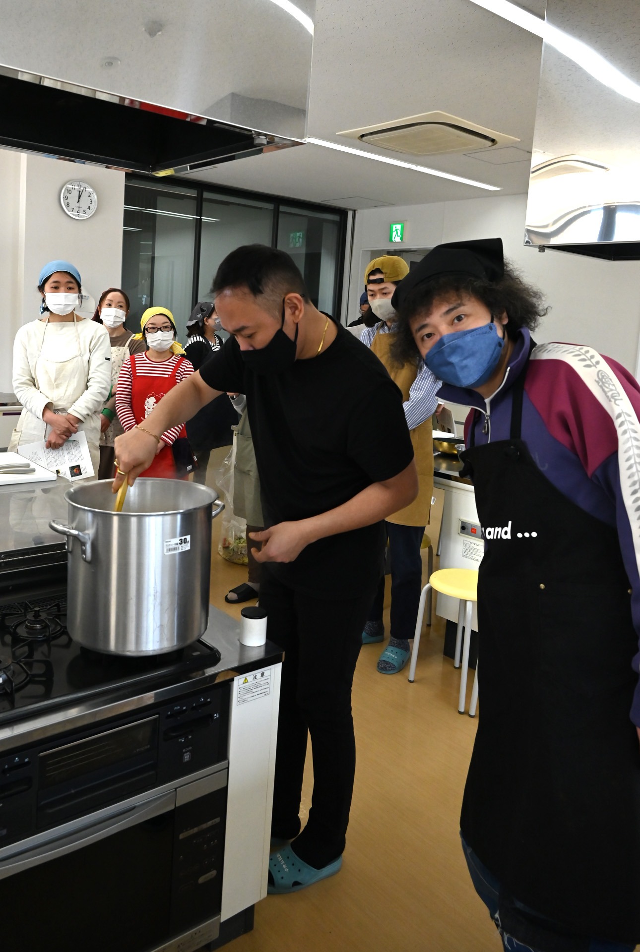 レンズ豆のスープをかきまぜる石濱匡雄とU-zhaan。