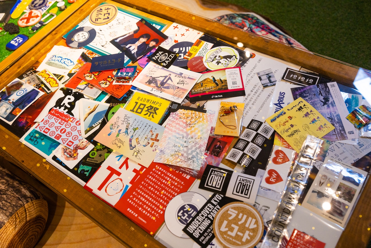 別のテーブルにはRADWIMPSにまつわるグッズやノベルティが。