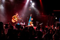 アコースティックギターを弾き終え、ピースサインを掲げる山田義孝（Vo）。（撮影：白石達也）