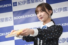 「言葉の海をさまよう」をカメラマンに差し出す鈴木絢音（乃木坂46）。