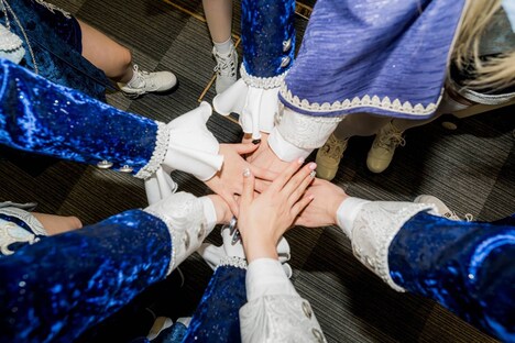 円陣を組むAVAMの手。