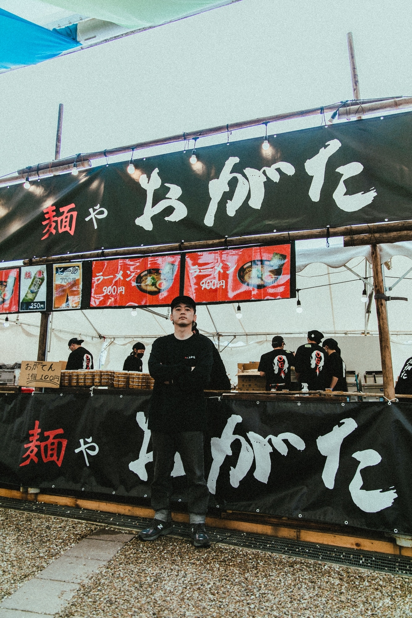 自身がプロデュースしているラーメン店・麺や おがたの前に立つ04 Limited SazabysのRYU-TA（G, Cho）。